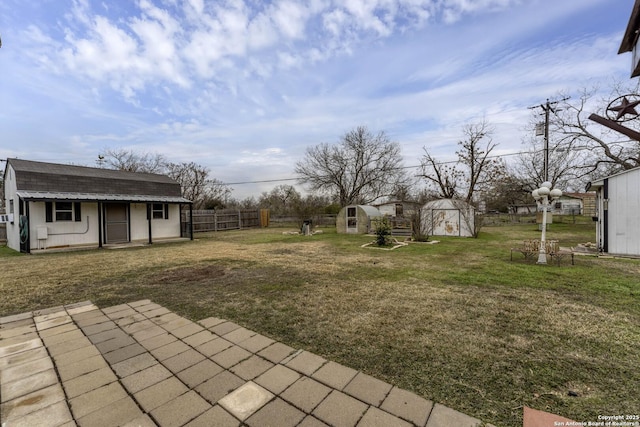 view of yard featuring a storage unit and a patio