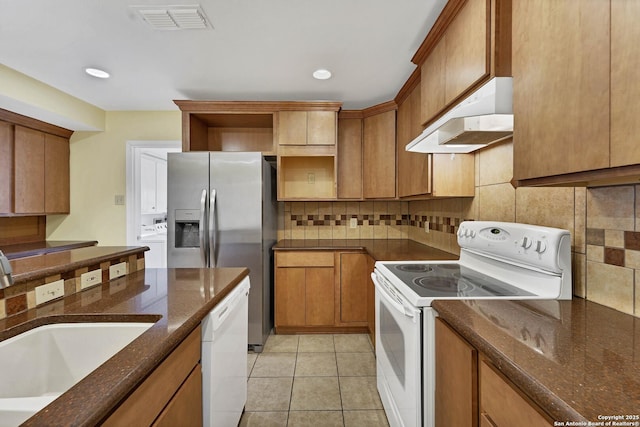 kitchen featuring tasteful backsplash, sink, white appliances, and light tile patterned flooring