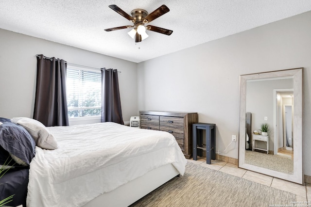 tiled bedroom featuring ceiling fan and a textured ceiling