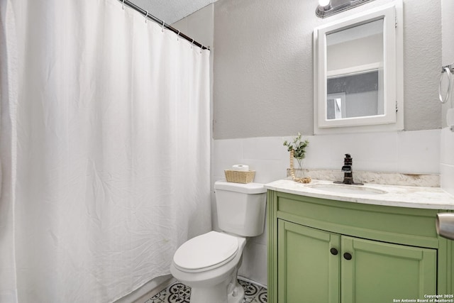 bathroom featuring a textured ceiling, toilet, and vanity