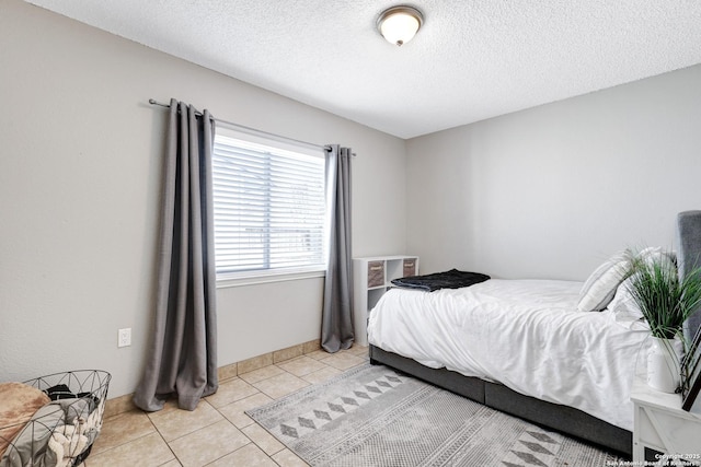 bedroom with a textured ceiling and light tile patterned floors