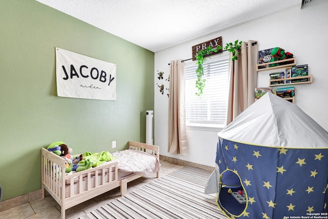 tiled bedroom featuring a textured ceiling and a crib