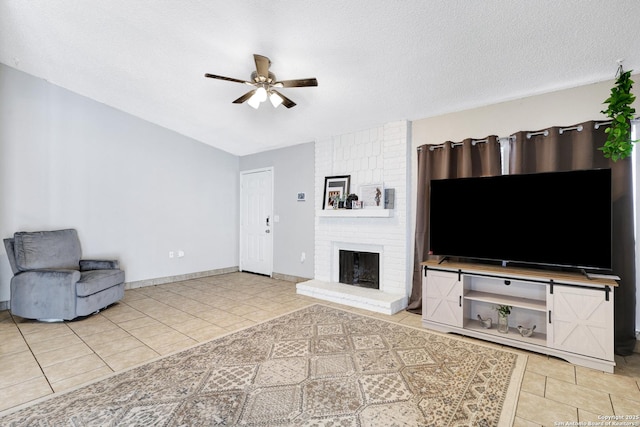 living room with a brick fireplace, a textured ceiling, tile patterned floors, and ceiling fan