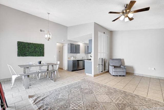 interior space with high vaulted ceiling, ceiling fan with notable chandelier, and a textured ceiling