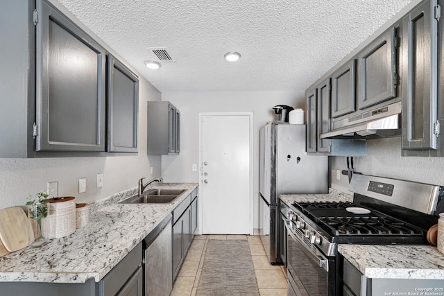 kitchen with sink, appliances with stainless steel finishes, gray cabinetry, a textured ceiling, and light tile patterned floors