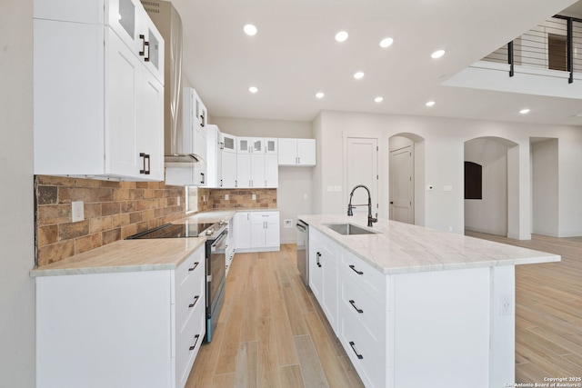 kitchen featuring sink, white cabinetry, appliances with stainless steel finishes, and an island with sink