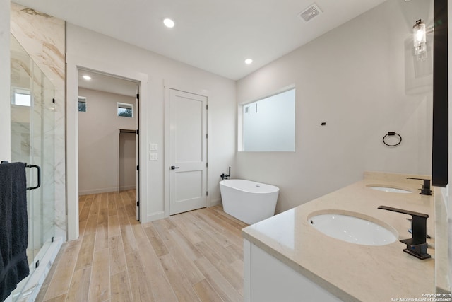 bathroom with separate shower and tub, vanity, and hardwood / wood-style floors