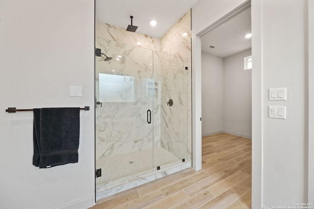 bathroom featuring a shower with door