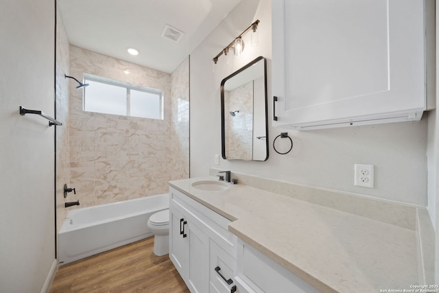 full bathroom with toilet, tiled shower / bath combo, vanity, and hardwood / wood-style floors