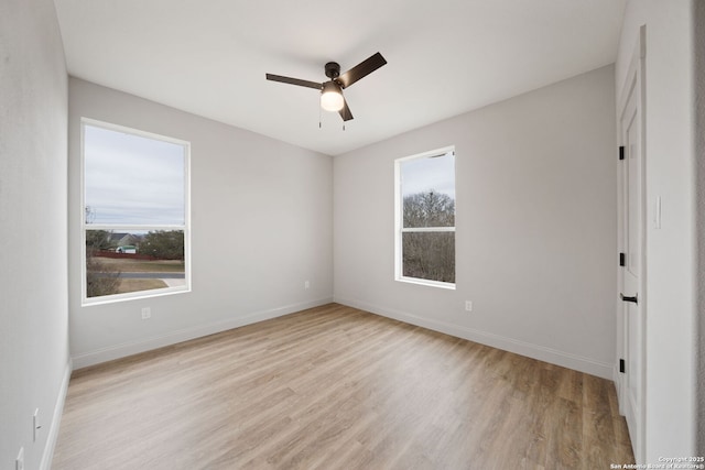 unfurnished room featuring ceiling fan, a wealth of natural light, and light hardwood / wood-style flooring