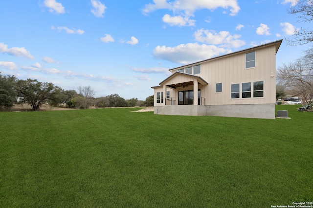 rear view of property featuring a lawn, central air condition unit, and ceiling fan