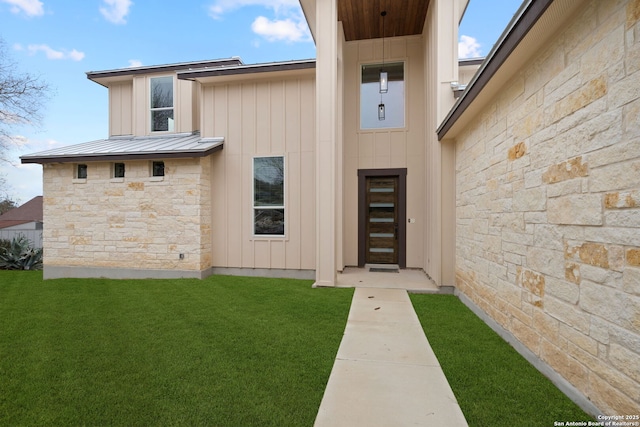 view of exterior entry with a lawn