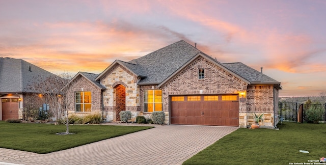 view of front of home featuring a garage and a lawn