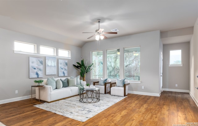 living room with vaulted ceiling, ceiling fan, plenty of natural light, and wood-type flooring