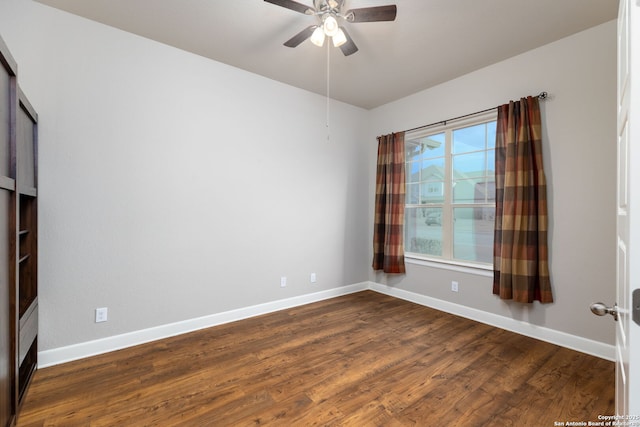 empty room with ceiling fan and dark wood-type flooring