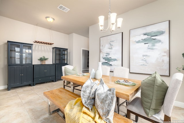 dining room featuring light tile patterned floors and a notable chandelier