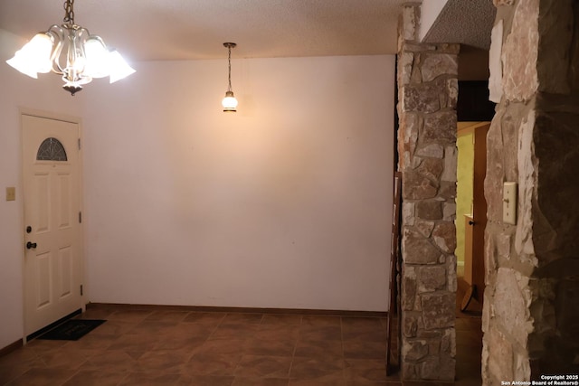 entryway with a textured ceiling and an inviting chandelier