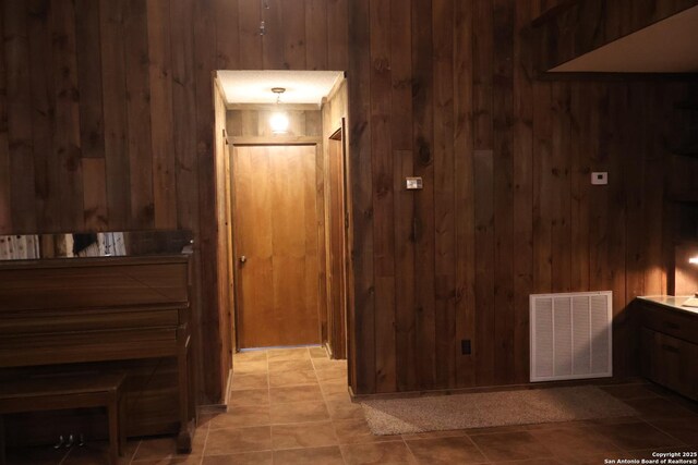 hallway featuring wooden walls