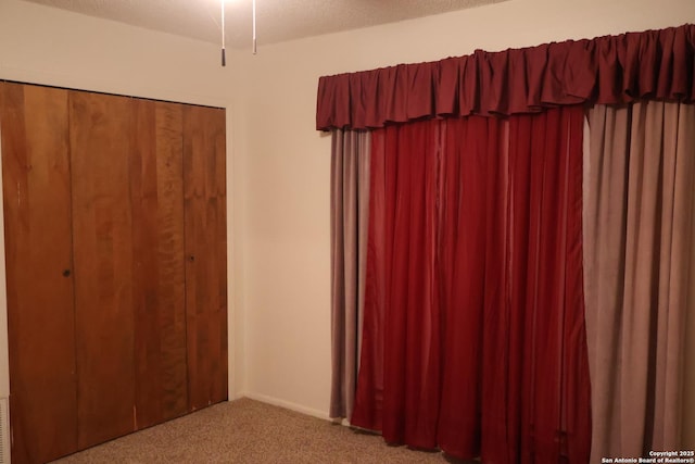 unfurnished bedroom featuring carpet floors and a textured ceiling