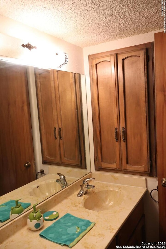 bathroom with a textured ceiling and vanity