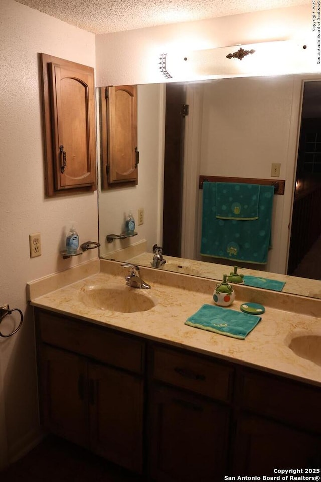 bathroom with a textured ceiling and vanity