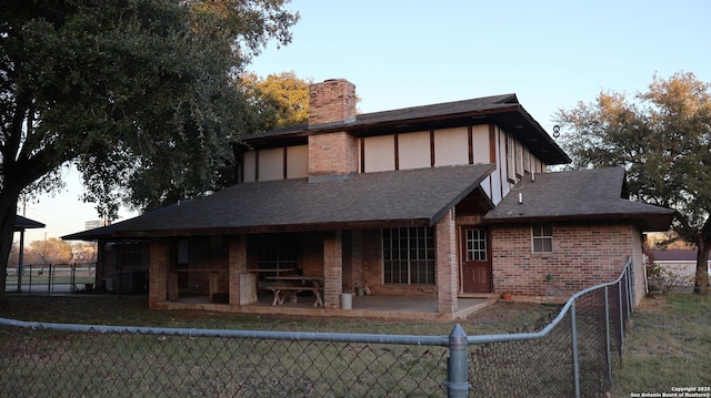 rear view of property featuring a patio area and a lawn