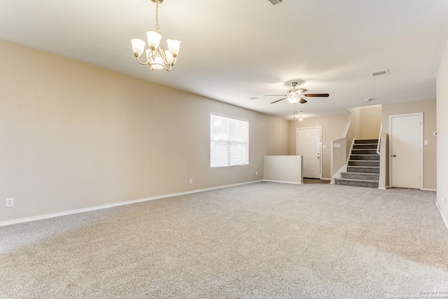 carpeted empty room featuring ceiling fan with notable chandelier