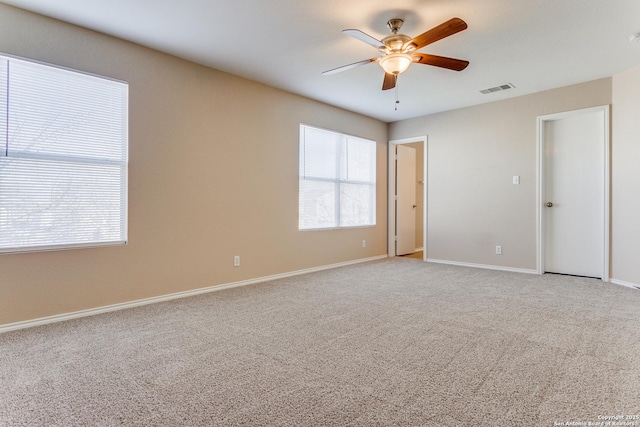 carpeted spare room featuring ceiling fan