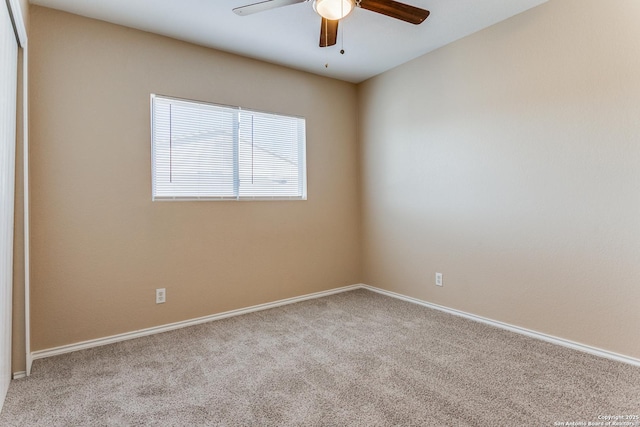 empty room featuring ceiling fan and light colored carpet