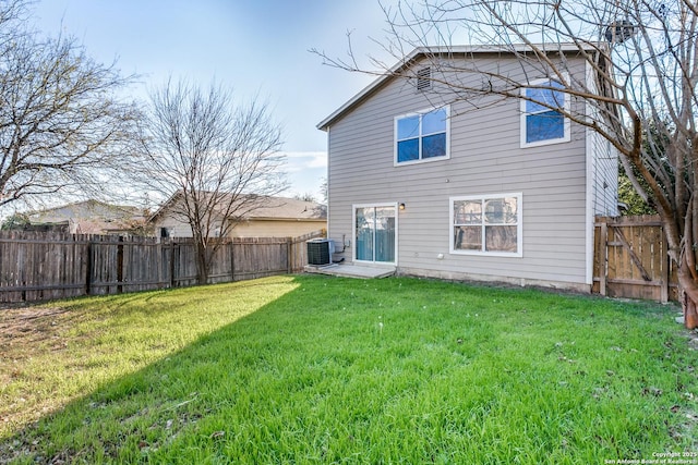 back of property featuring a lawn and central air condition unit