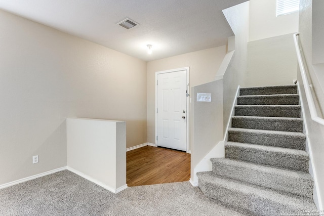 foyer entrance featuring carpet flooring