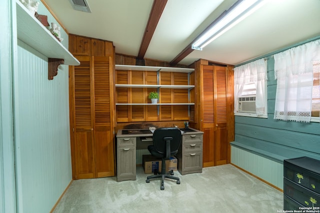 office with wooden walls, cooling unit, light colored carpet, built in desk, and lofted ceiling with beams