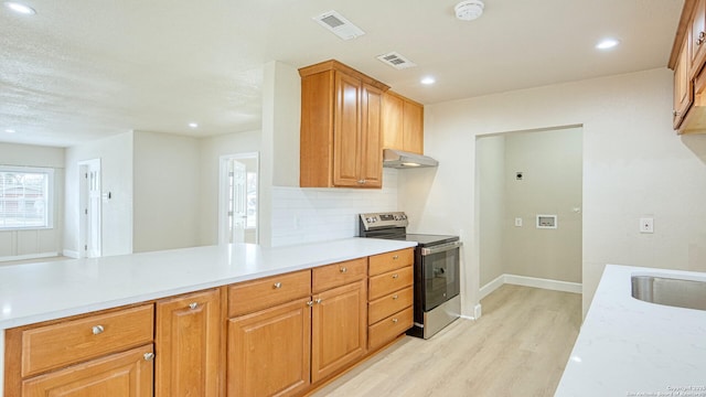 kitchen featuring tasteful backsplash, sink, stainless steel electric stove, and light hardwood / wood-style flooring