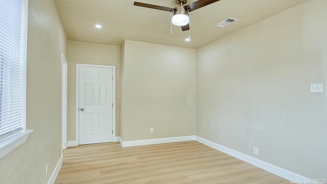 empty room with ceiling fan and light hardwood / wood-style flooring