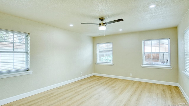 spare room with ceiling fan, light wood-type flooring, and a textured ceiling