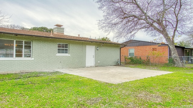 rear view of house with a patio area and a lawn