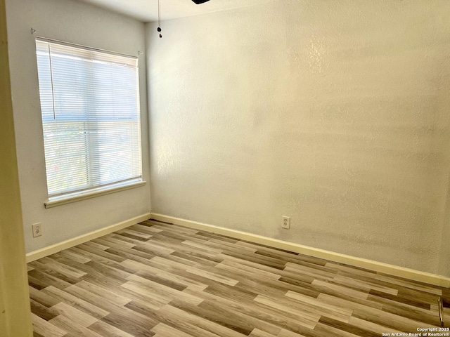 unfurnished room featuring ceiling fan, a wealth of natural light, and light hardwood / wood-style flooring