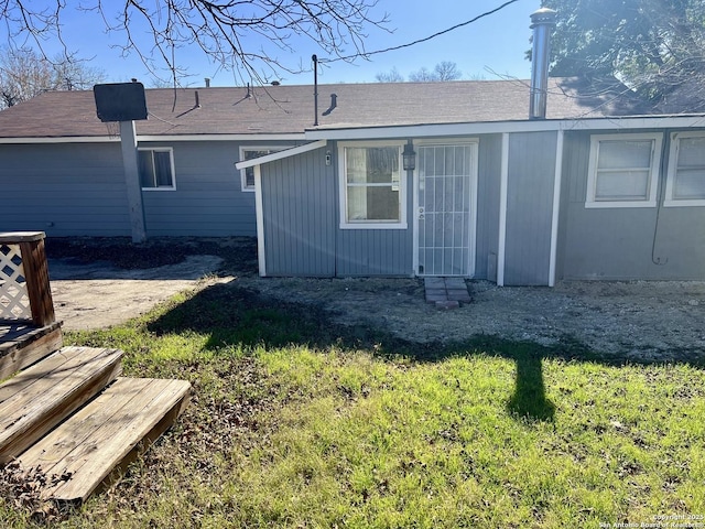 rear view of property featuring a lawn