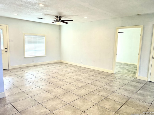 tiled spare room with ceiling fan and a textured ceiling