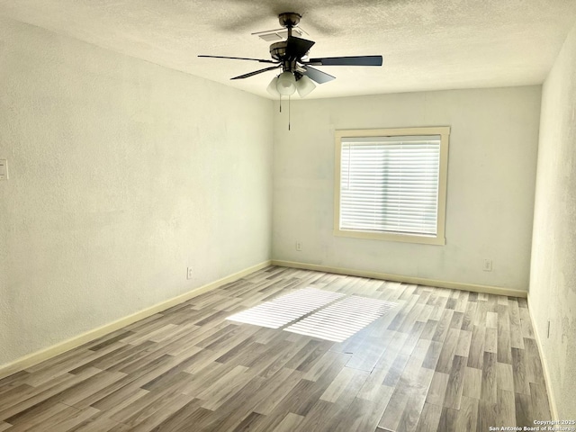 spare room with ceiling fan, a textured ceiling, and light hardwood / wood-style flooring