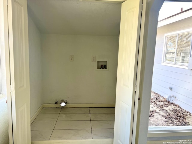 clothes washing area featuring light tile patterned floors and washer hookup