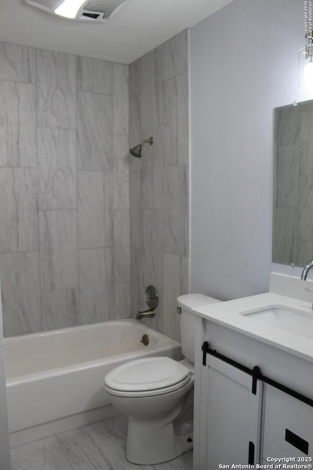 full bathroom featuring toilet, tiled shower / bath, and vanity