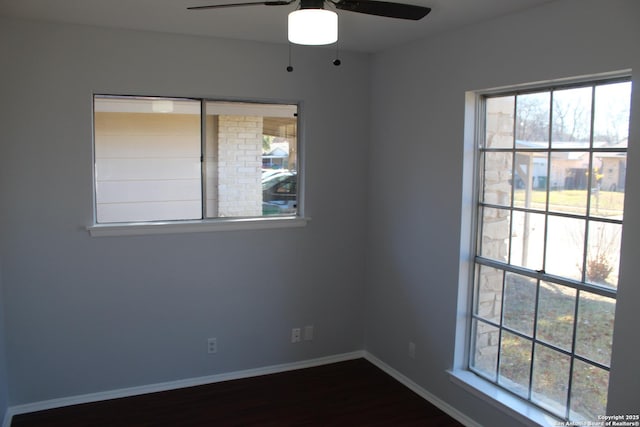 unfurnished room featuring dark hardwood / wood-style floors, ceiling fan, and plenty of natural light