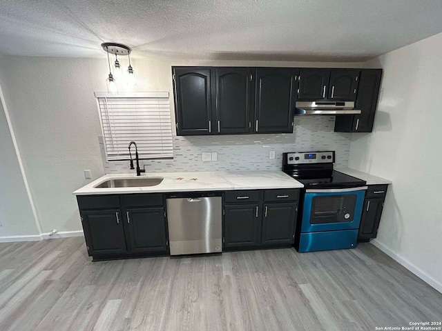 kitchen with light hardwood / wood-style floors, appliances with stainless steel finishes, decorative light fixtures, a textured ceiling, and sink