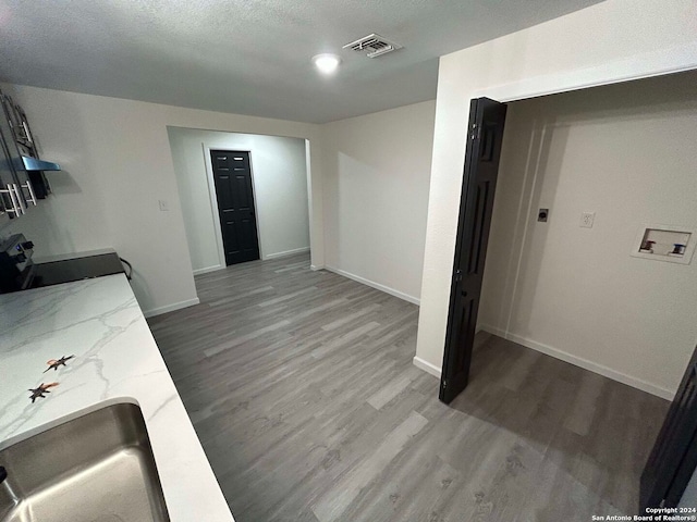 interior space with sink, a textured ceiling, and hardwood / wood-style flooring