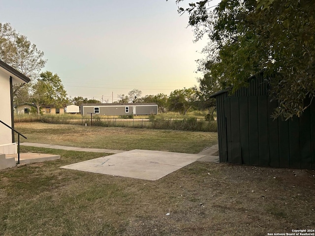 yard at dusk with a patio area