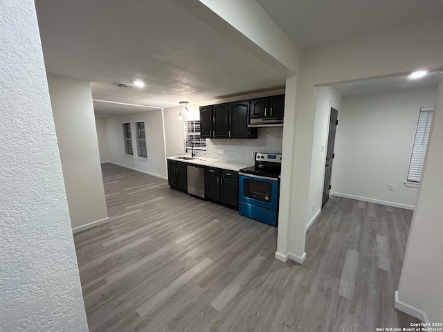 kitchen featuring tasteful backsplash, appliances with stainless steel finishes, sink, and light hardwood / wood-style floors