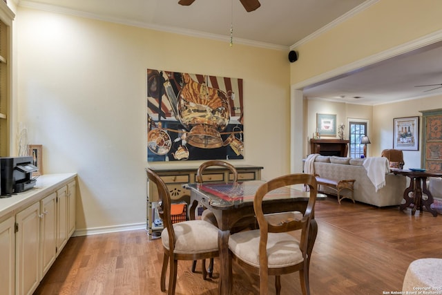 dining room with ceiling fan, crown molding, and light hardwood / wood-style floors