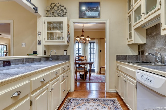 kitchen featuring ornamental molding, sink, white dishwasher, and light hardwood / wood-style floors