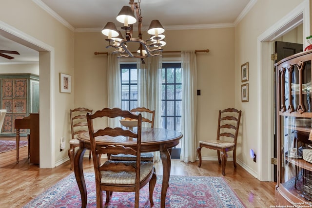 dining area featuring ornamental molding, ceiling fan with notable chandelier, and light hardwood / wood-style flooring